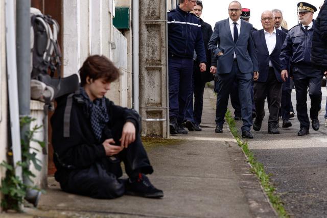 France's Interior Minister Laurent Nunez (C) walks next to Cher Prefect Philippe Le Moing Surzur (R) as he arrives near a "teknival" rave party at a military site in Cornusse, near Bourges, in Bengy-sur-Craon, central France on May 3, 2026. Between 17,000 and 40,000 people participate in the free party which has been taking place, without major incident, since May 1, 2026. The gathering comes as the French parliament is seeking to tighten legislation against unauthorised rave parties, introducing prison sentences for organisers and fines for attendees. (Photo by Kenzo TRIBOUILLARD / POOL / AFP)