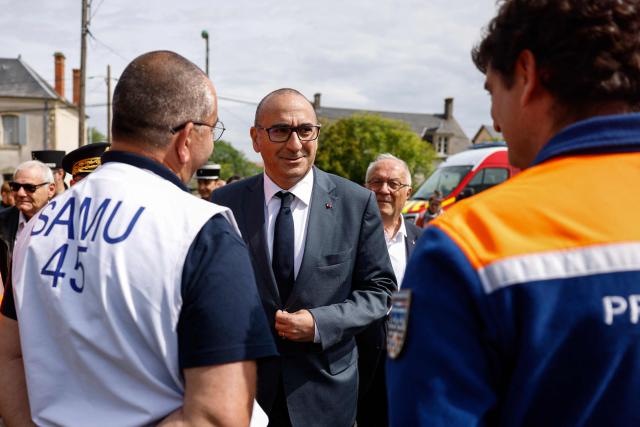 France's Interior Minister Laurent Nunez (C) greets emergency medical service and civil protection members as he visits an advanced medical post on the sidelines of a "teknival" rave party at a military site in Cornusse, near Bourges, in Bengy-sur-Craon, central France on May 3, 2026. Between 17,000 and 40,000 people participate in the free party which has been taking place, without major incident, since May 1, 2026. The gathering comes as the French parliament is seeking to tighten legislation against unauthorised rave parties, introducing prison sentences for organisers and fines for attendees. (Photo by Kenzo TRIBOUILLARD / POOL / AFP)