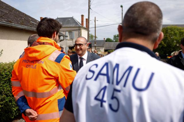 France's Interior Minister Laurent Nunez (C) greets emergency medical service and civil protection members as he visits an advanced medical post on the sidelines of a "teknival" rave party at a military site in Cornusse, near Bourges, in Bengy-sur-Craon, central France on May 3, 2026. Between 17,000 and 40,000 people participate in the free party which has been taking place, without major incident, since May 1, 2026. The gathering comes as the French parliament is seeking to tighten legislation against unauthorised rave parties, introducing prison sentences for organisers and fines for attendees. (Photo by Kenzo TRIBOUILLARD / POOL / AFP)