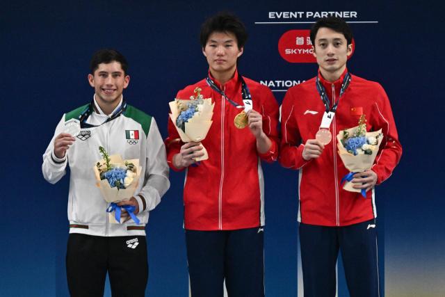 Gold medallist China’s Bai Yuming (C) celebrates on the podium with silver medallist Mexicoґs Randal Willars Valdez (L) and bronze medallist Chinaґs Lian Junjie after competing in the men’s 10m platform event at the World Aquatics Diving World Cup Super Finals in Beijing on May 3, 2026. (Photo by Pedro PARDO / AFP)
