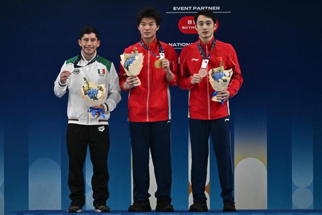 Gold medallist China’s Bai Yuming (C) celebrates on the podium with silver medallist Mexicoґs Randal Willars Valdez (L) and bronze medallist Chinaґs Lian Junjie after competing in the men’s 10m platform event at the World Aquatics Diving World Cup Super Finals in Beijing on May 3, 2026. (Photo by Pedro PARDO / AFP)
