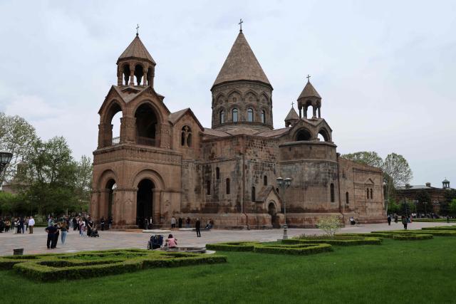 Pedestrians visit the cathedral of Saint Etchmiadzin, in Etchmiadzin, near Yerevan in Armenia, on May 3 2026. (Photo by Ludovic MARIN / AFP)