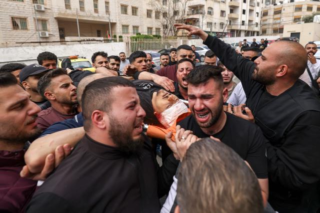 EDITORS NOTE: Graphic content / Mourners carry the body of a Palestinian man, who was allegedly killed in clashes with Israeli soldiers during a raid in the Israeli-occupied West Bank city of Nablus on May 3, 2026. Violence has surged in the Palestinian territory since the start of the war in Gaza in October 2023. According to an AFP tally based on Palestinian health ministry figures, Israeli troops or settlers have killed at least 1,068 Palestinians -- many of them militants, but also scores of civilians -- in the West Bank since then. Official Israeli figures say at least 46 Israelis, including soldiers and civilians, have been killed in Palestinian attacks or during Israeli military operations in the same period. (Photo by JAAFAR ASHTIYEH / AFP)