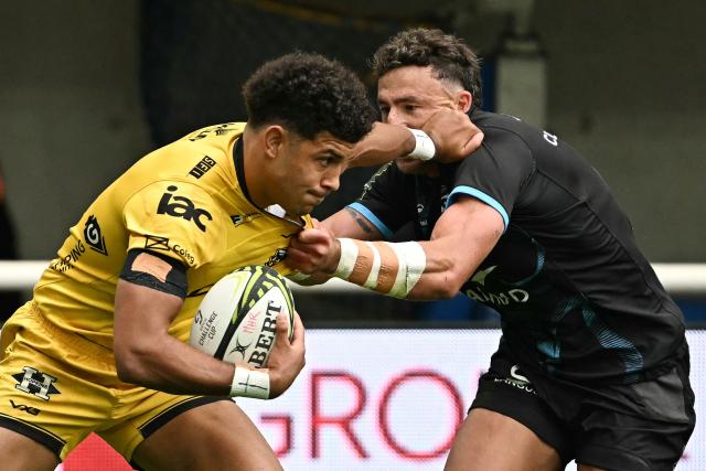 Dragon's Welsh wing Rio Dyer (L) runs to evade Montpellier’s Australian full-back Tom Banks  during the European Challenge Cup rugby union semi-final match between Montpellier Herault Rugby and Dragons RFC at the Septeo Stadium in Montpellier, southern France, on May 3, 2026. (Photo by Gabriel BOUYS / AFP)