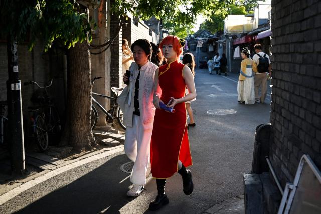 People walk through an alley in Beijing on May 3, 2026 on the third day of a five-day national May Day holiday. (Photo by GREG BAKER / AFP)