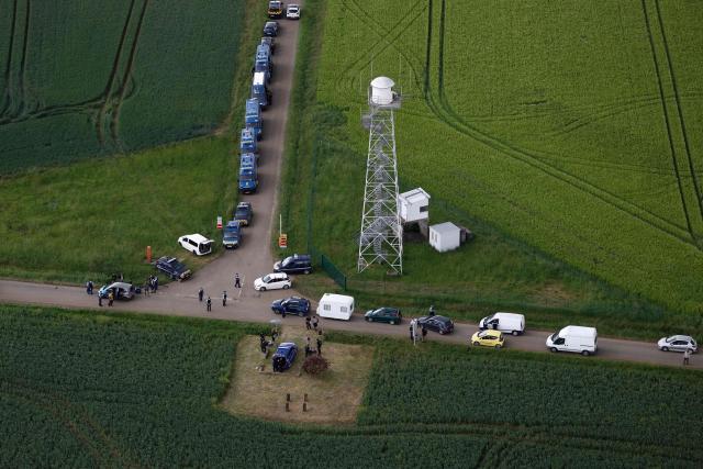 An aerial view shows gendarmes carrying out checks as partygoers leave the site of a @teknival" rave party at a military site in Cornusse, near Bourges, central France on May 3, 2026. Between 17,000 and 40,000 people participate in the free party which has been taking place, without major incident, since May 1, 2026. The gathering comes as the French parliament is seeking to tighten legislation against unauthorised rave parties, introducing prison sentences for organisers and fines for attendees. (Photo by Kenzo TRIBOUILLARD / AFP)