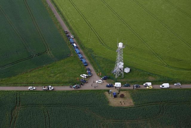 An aerial view shows gendarmes carrying out checks as partygoers leave the site of a @teknival" rave party at a military site in Cornusse, near Bourges, central France on May 3, 2026. Between 17,000 and 40,000 people participate in the free party which has been taking place, without major incident, since May 1, 2026. The gathering comes as the French parliament is seeking to tighten legislation against unauthorised rave parties, introducing prison sentences for organisers and fines for attendees. (Photo by Kenzo TRIBOUILLARD / AFP)