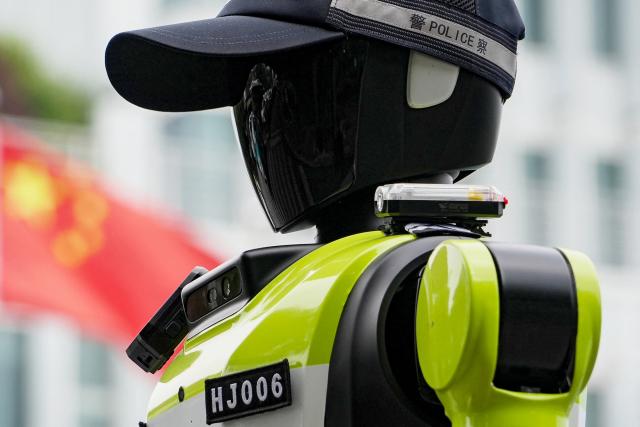 A humanoid robot police officer is seen on a street in Hangzhou, in China’s eastern Zhejiang province on May 3, 2026 on the third day of a five-day national May Day holiday. The tech hub's traffic police deployed 15 humanoid robots in total to bolster their ranks on May 1. (Photo by Agatha CANTRILL / AFP)