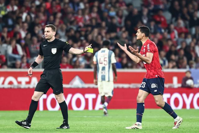 Lille's Algerian defender #23 Aissa Mandi (R) reacts as he receives a yellow card during the French L1 football match between Lille LOSC and Le Havre AC at the Pierre Mauroy stadium in Villeneuve-d'Ascq, northern France, on May 3, 2026. (Photo by Sameer Al-DOUMY / AFP)
