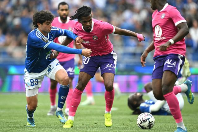 Toulouse’s French forward #10 Yann Gboho (C) fights for the ball with Strasbourg’s Portuguese midfielder #83 Rafael Luis (L) during the French L1 football match between RC Strasbourg Alsace and Toulouse FC at Stade de la Meinau in Strasbourg on May 3, 2026. (Photo by SEBASTIEN BOZON / AFP)