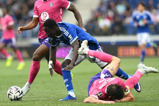 Strasbourg’s French forward #34 Jean-Baptiste Bosey (C) fights for the ball with Toulouse’s British defender #04 Charlie Cresswell (R) during the French L1 football match between RC Strasbourg Alsace and Toulouse FC at Stade de la Meinau in Strasbourg, eastern France, on May 3, 2026. (Photo by SEBASTIEN BOZON / AFP)
