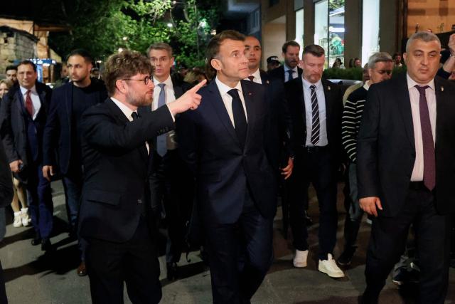 France's President Emmanuel Macron and France's Ambassador to Armenia Olivier Decottignies walk on a street on the eve of the 8th European Political Community (EPC) summit in Yerevan on May 3, 2026. (Photo by Ludovic MARIN / AFP)