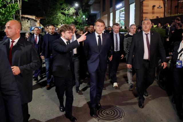 France's President Emmanuel Macron and France's Ambassador to Armenia Olivier Decottignies walk on a street on the eve of the 8th European Political Community (EPC) summit in Yerevan on May 3, 2026. (Photo by Ludovic MARIN / AFP)
