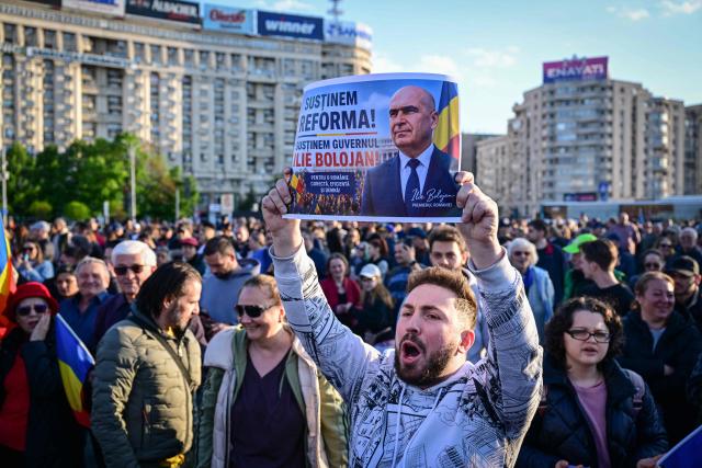 Supporters of Prime Minister Ilie Bolojan gather in Victoria Square, in front of the Romanian Government headquarters, on May 3, 2026, to demonstrate their backing for his minority government. The rally comes as the pro-EU leader faces a critical no-confidence vote scheduled for May 5, following the withdrawal of support from the nationalist-sovereignist AUR party and Social Democratic Party (PSD). Demonstrators, carrying Romanian and European Union flags, are calling for the continuation of Bolojans fiscal reforms and the stability of the current cabinet. (Photo by Daniel MIHAILESCU / AFP)