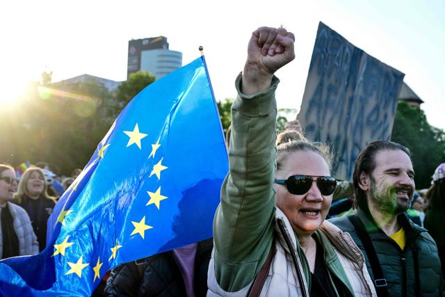 Supporters of Prime Minister Ilie Bolojan with EU flags gather in Victoria Square, in front of the Romanian Government headquarters, on May 3, 2026, to demonstrate their backing for his minority government. The rally comes as the pro-EU leader faces a critical no-confidence vote scheduled for May 5, following the withdrawal of support from the nationalist-sovereignist AUR party and Social Democratic Party (PSD). Demonstrators, carrying Romanian and European Union flags, are calling for the continuation of Bolojans fiscal reforms and the stability of the current cabinet. (Photo by Daniel MIHAILESCU / AFP)