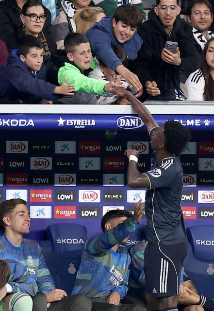 Real Madrid's Brazilian forward #07 Vinicius Junior shakes hands with young fans during the Spanish league football match between RCD Espanyol and Real Madrid CF at RCDE Stadium in Cornella de Llobregat on May 3, 2026. (Photo by Josep LAGO / AFP)