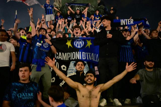 Inter Milan’s supporters celebrate at Piazza Duomo after their team clinched their 21st scudetto following the Italian Serie A football match between Inter Milan and Parma, in Milan, on May 3, 2026. (Photo by PIERO CRUCIATTI / AFP)