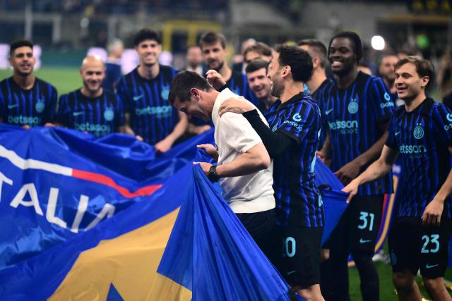 Inter Milan's players celebrate with Inter Milan's Romanian head coach Cristian Chivu after winning their 21st 'scudetto' following the Italian Serie A football match between Inter Milan and Parma at San Siro stadium in Milan, on May 3, 2026. (Photo by Marco BERTORELLO / AFP)