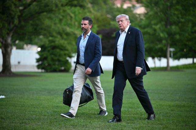 US President Donald Trump and Donald Trump Jr. walk on the south lawn toward the White House in Washington, DC, on May 3, 2026. Trump spent the weekend at his Mar-a-Lago resort in Palm Beach, Florida and his Doral Miami resort. (Photo by Mandel NGAN / AFP)