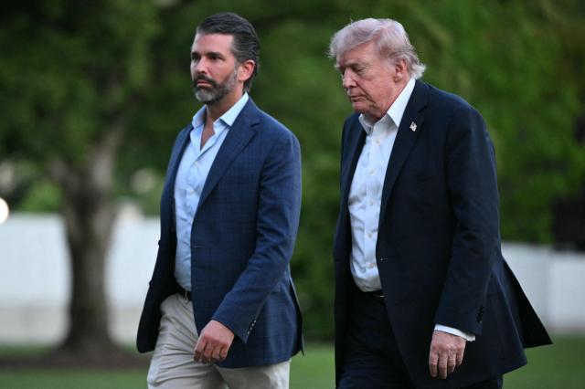 US President Donald Trump and Donald Trump Jr. walk on the south lawn toward the White House in Washington, DC, on May 3, 2026. Trump spent the weekend at his Mar-a-Lago resort in Palm Beach, Florida and his Doral Miami resort. (Photo by Mandel NGAN / AFP)