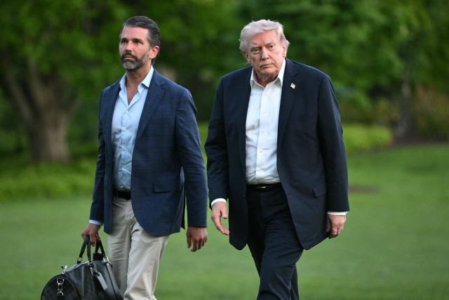 US President Donald Trump and Donald Trump Jr. walk on the south lawn toward the White House in Washington, DC, on May 3, 2026. Trump spent the weekend at his Mar-a-Lago resort in Palm Beach, Florida and his Doral Miami resort. (Photo by Mandel NGAN / AFP)