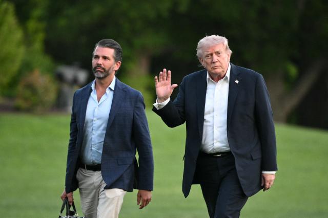 US President Donald Trump and Donald Trump Jr. walk on the south lawn toward the White House in Washington, DC, on May 3, 2026. Trump spent the weekend at his Mar-a-Lago resort in Palm Beach, Florida and his Doral Miami resort. (Photo by Mandel NGAN / AFP)