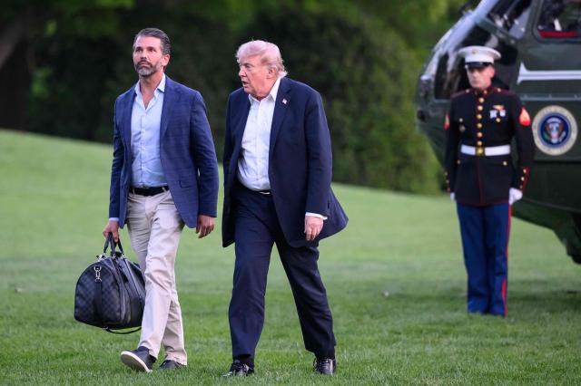 US President Donald Trump and Donald Trump Jr. walk on the south lawn toward the White House in Washington, DC, on May 3, 2026. Trump spent the weekend at his Mar-a-Lago resort in Palm Beach, Florida and his Doral Miami resort. (Photo by Mandel NGAN / AFP)