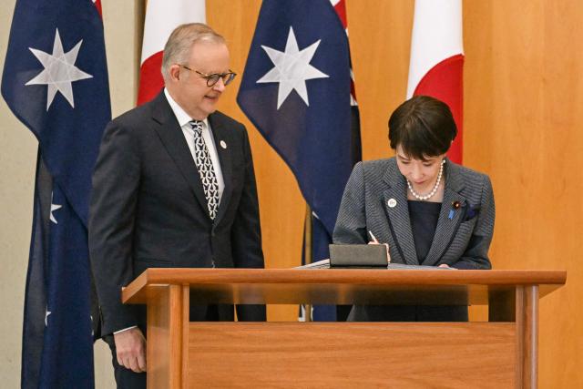 Japan's Prime Minister Sanae Takaichi signs the visitors’ book alongside Australia's Prime Minister Anthony Albanese at Parliament House in Canberra on May 4, 2026. (Photo by Saeed Khan / AFP)