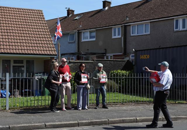 Supporters of Labour Party Senedd election candidate Huw Thomas pose for a photograph after canvassing in the Llanrumney suburb of Cardiff, South Wales on April 23, 2026. Wales -- the cradle of Britain's revered National Health Service and a former industrial powerhouse -- has been a Labour Party stronghold for well over a century. But that is set to end in crunch polls next week as impatient Britons abandon their old political loyalties for anti-establishment parties amid persistent cost of living pressures. (Photo by Darren Staples / AFP) / TO GO WITH AFP STORY by Peter HUTCHISON