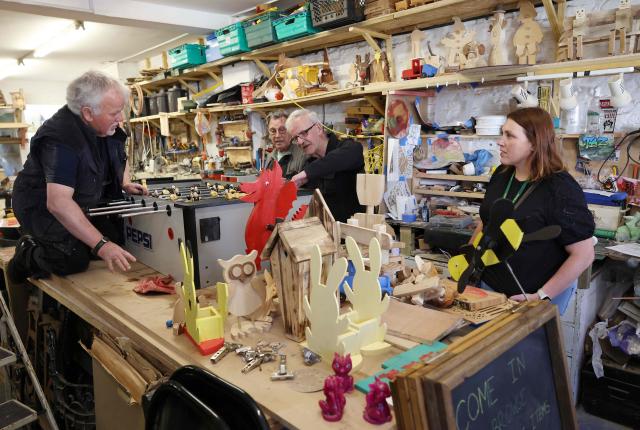 Plaid Cymru candidate Heledd Fychan (R) talks with Men in Sheds participants ahead of the Senedd election in Pontypridd, South Wales on April 24, 2026. Wales -- the cradle of Britain's revered National Health Service and a former industrial powerhouse -- has been a Labour Party stronghold for well over a century. But that is set to end in crunch polls next week as impatient Britons abandon their old political loyalties for anti-establishment parties amid persistent cost of living pressures. (Photo by Darren Staples / AFP) / TO GO WITH AFP STORY by Peter HUTCHISON