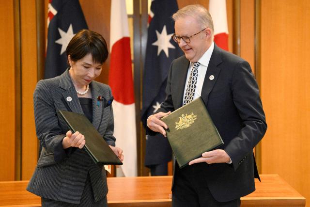 Japan's Prime Minister Sanae Takaichi (L) and Australia's Prime Minister Anthony Albanese exchange documents in a signing ceremony for a joint declaration of economic security cooperation at Parliament House in Canberra on May 4, 2026. (Photo by Saeed KHAN / AFP)