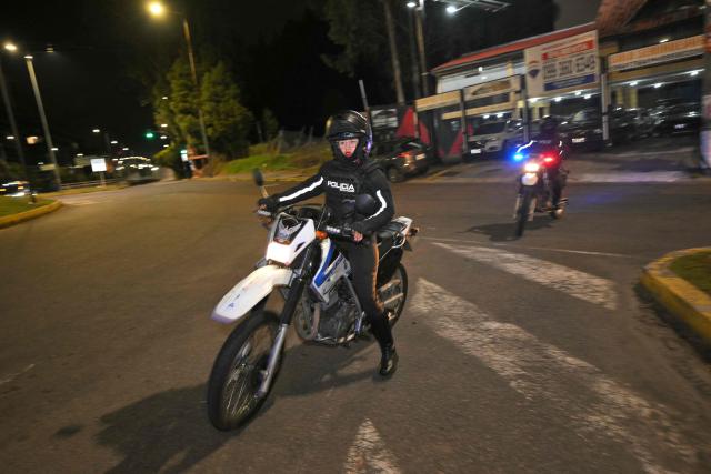 A woman police officer patrols the streets following a curfew imposed by Ecuador’s President Daniel Noboa in Quito on May 3, 2026. (Photo by Rodrigo BUENDIA / AFP)