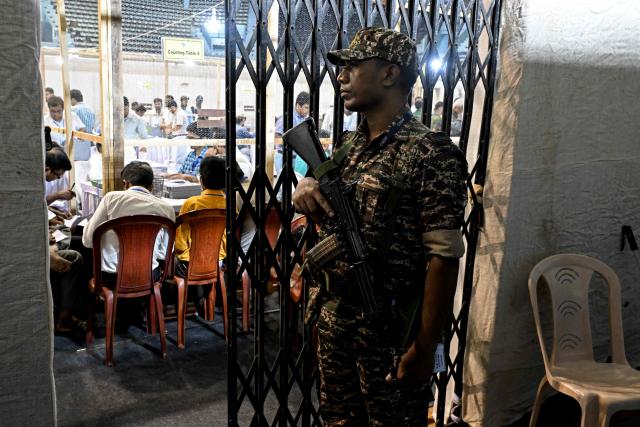 A Central Reserve Police Force (CRPF) personnel stands guard as election officials count votes after the West Bengal Legislative Assembly elections at the Netaji Indoor Stadium in Kolkata on May 4, 2026. Vote counting in key Indian state elections were underway on May 4 under tight security, with the focus on West Bengal, where Prime Minister Narendra Modi's party is hoping for crucial gains. (Photo by Dibyangshu SARKAR / AFP)