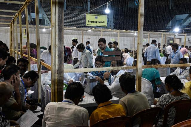 Election officials count votes after the West Bengal Legislative Assembly elections at the Netaji Indoor Stadium in Kolkata on May 4, 2026. Vote counting in key Indian state elections were underway on May 4 under tight security, with the focus on West Bengal, where Prime Minister Narendra Modi's party is hoping for crucial gains. (Photo by Dibyangshu SARKAR / AFP)