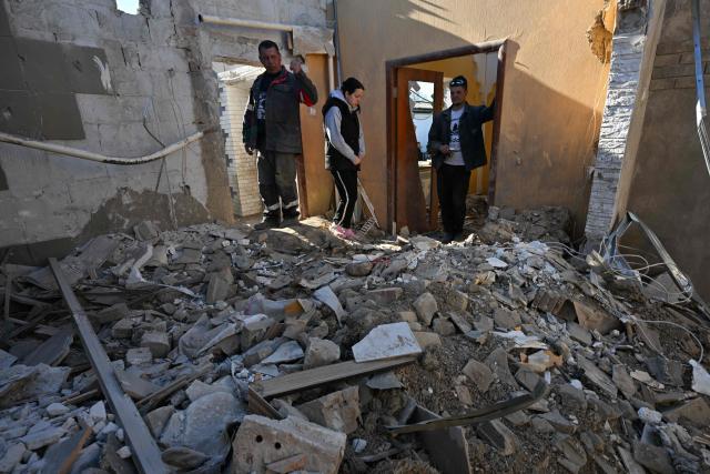 Local residents clear debris of a house destroyed by a recent drone attack in the settlement of Stariy Krym in the Donetsk region, Russian-controlled Ukraine, on May 3, 2026, amid the ongoing Russian-Ukrainian conflict. (Photo by AFP)