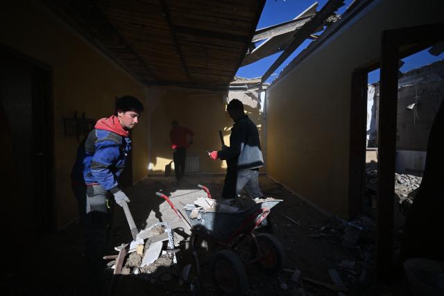 Local residents clear debris of a house destroyed by a recent drone attack in the settlement of Stariy Krym in the Donetsk region, Russian-controlled Ukraine, on May 3, 2026, amid the ongoing Russian-Ukrainian conflict. (Photo by AFP)