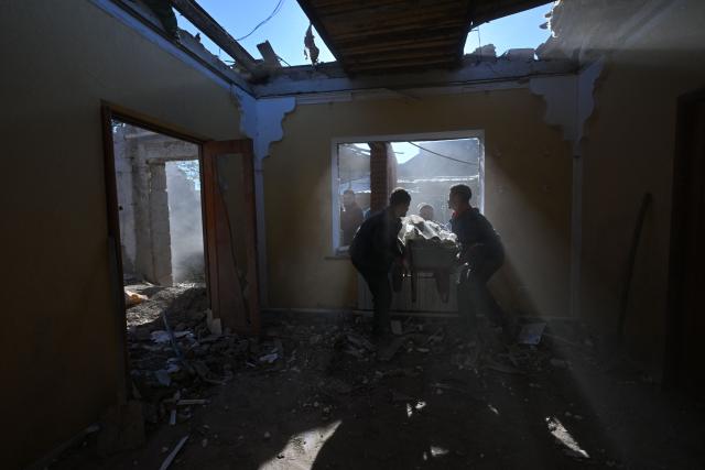 Local residents clear debris of a house destroyed by a recent drone attack in the settlement of Stariy Krym in the Donetsk region, Russian-controlled Ukraine, on May 3, 2026, amid the ongoing Russian-Ukrainian conflict. (Photo by AFP)