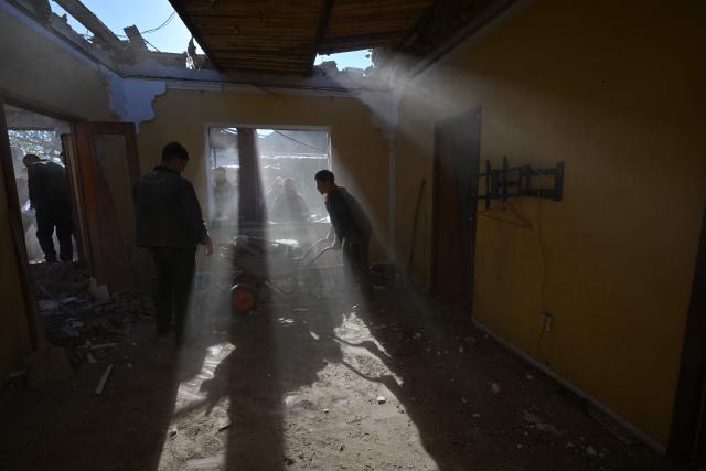Local residents clear debris of a house destroyed by a recent drone attack in the settlement of Stariy Krym in the Donetsk region, Russian-controlled Ukraine, on May 3, 2026, amid the ongoing Russian-Ukrainian conflict. (Photo by AFP)