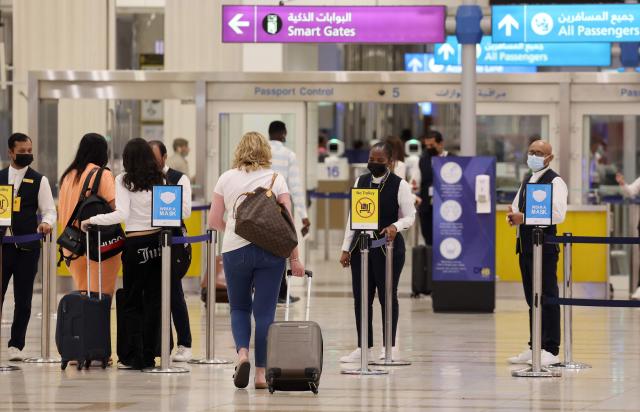 (FILES) A picture shows passengers walking towards the gates at terminal 3 at Dubai international Airport, in the Gulf emirate of Dubai, on August 16, 2022. Dubai airport's passenger traffic plunged by two-thirds in March following Iran's attacks on the United Arab Emirates during the Middle East war, the emirate's media office said in a statement on May 4, 2026. Traveller numbers at Dubai International, usually the world's busiest for international passenger traffic, sank to 2.5 million, down 66 percent year on year, Dubai Media Office said. (Photo by Giuseppe CACACE / AFP)