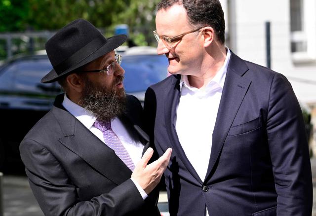 Rabbi Yehuda Teichtal (L) greets Jens Spahn, parliamentary group leader at the Bundestag (lower house of parliament) of the conservative CDU/CSU party union, in front of the Chabad Synagogue in Berlin, Germany, where the leadership of the Christian Democratic Union (CDU) party meets on May 4, 2026. (Photo by Tobias SCHWARZ / AFP)