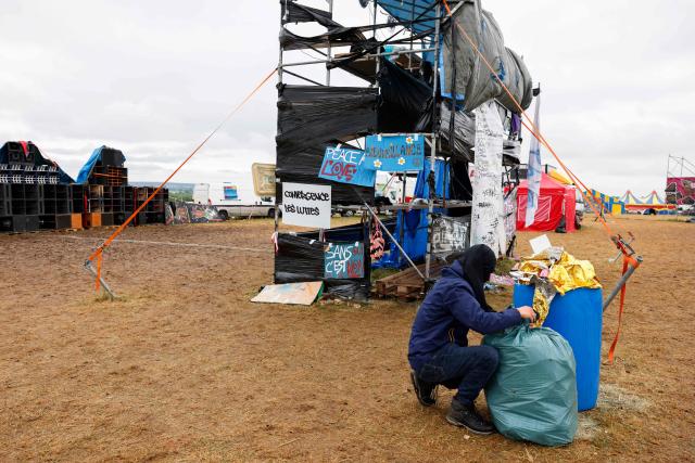 A partygoer cleans the military site where a "teknival" rave party took place in Cornusse, near Bourges, central France on May 4, 2026. Between 17,000 and 40,000 people participate in the free party which has been taking place, without major incident, since May 1, 2026. The gathering comes as the French parliament is seeking to tighten legislation against unauthorised rave parties, introducing prison sentences for organisers and fines for attendees. (Photo by Kenzo TRIBOUILLARD / AFP)