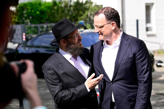 Rabbi Yehuda Teichtal (L) greets Jens Spahn, parliamentary group leader at the Bundestag (lower house of parliament) of the conservative CDU/CSU party union, in front of the Chabad Synagogue in Berlin, Germany, where the leadership of the Christian Democratic Union (CDU) party meets on May 4, 2026. (Photo by Tobias SCHWARZ / AFP)