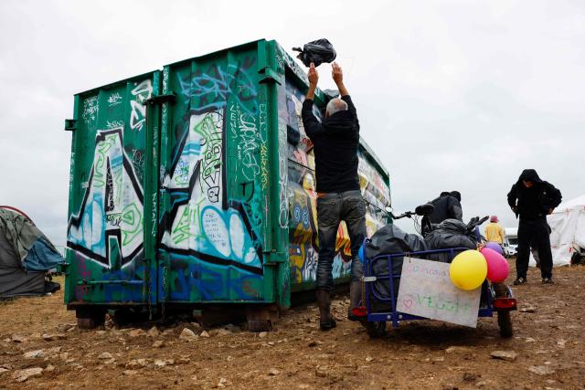 A partygoer cleans the military site where a "teknival" rave party took place in Cornusse, near Bourges, central France on May 4, 2026. Between 17,000 and 40,000 people participate in the free party which has been taking place, without major incident, since May 1, 2026. The gathering comes as the French parliament is seeking to tighten legislation against unauthorised rave parties, introducing prison sentences for organisers and fines for attendees. (Photo by Kenzo TRIBOUILLARD / AFP)