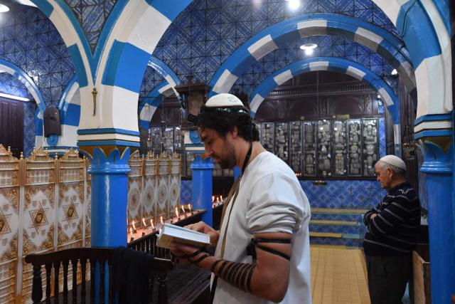 French Jewish pilgrims pray inside the historic Ghriba synagogue in the Tunisian resort island of Djerba, during the annual Jewish pilgrimage on May 4, 2026. This year's Jewish pilgrimage on Tunisia's island of Djerba will welcome more worshippers after two years of scaled-down participation due to safety concerns, organisers said on April 14, 2026. The pilgrimage to the Ghriba synagogue, Africa's oldest, has in the past drawn thousands of pilgrims from Europe and beyond, attracting international and local tourists as well. (Photo by FETHI BELAID / AFP)