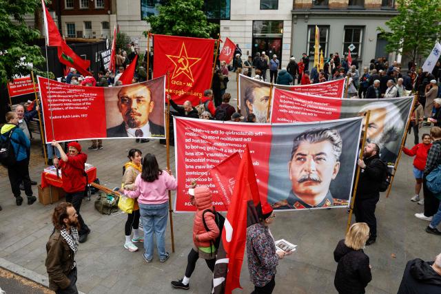 People hold banners showing historical Soviet figures Vladimir Lenin (L), Joseph Stalin (front C) and German philosopher Karl Marx (R) as they gather to take part in a May Day march and rally in central London on May 4, 2026, to mark the 100th anniversary of the "General Strike" in 1926. (Photo by Brook Mitchell / AFP)
