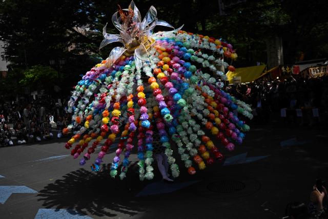 A festival participant spins an elaborate three-meter-tall decorated lantern tower known as Mant? through the streets of Fuchu during the Kurayami Matsuri, or "Festival of Darkness," at Okunitama Shrine in western Tokyo on May 4, 2026, as neighbourhood groups compete in an ancient tradition to keep their 50-kilogram towers twirling the longest while judges assess the artistry of each team's decorated pole. (Photo by Andrew CABALLERO-REYNOLDS / AFP)