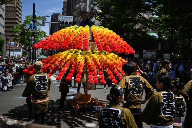 Festival participants prepare to spin an elaborate three-meter-tall decorated lantern tower known as Mant? through the streets of Fuchu during the Kurayami Matsuri, or "Festival of Darkness," at Okunitama Shrine in western Tokyo on May 4, 2026, as neighbourhood groups compete in an ancient tradition to keep their 50-kilogram towers twirling the longest while judges assess the artistry of each team's decorated pole. (Photo by Andrew CABALLERO-REYNOLDS / AFP)