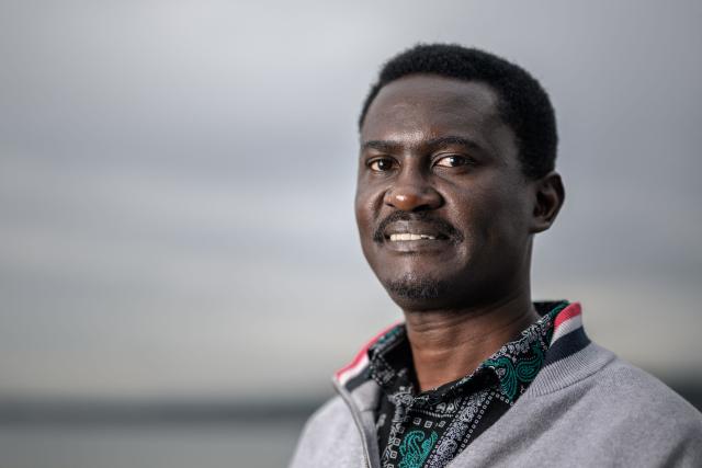 Laureate of the Kofi Annan Courage in Cartooning Award, Ugandan columnist, editorial cartoonist and author Jimmy Spire Ssentongo poses as part of the exhibition titled “Dessins pour la liberte” (“Drawings for Freedom”), held to mark World Press Freedom Day, on the shores of Lake Geneva in Geneva, on May 4, 2026. (Photo by Fabrice COFFRINI / AFP)