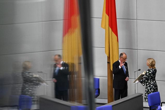 (FILES) German Chancellor Friedrich Merz takes the oath from President of the Bundestag (lower house of parliament) Julia Kloeckner after he was elected as Germany's new Chancellor during a swearing-in session at the Bundestag (lower house of parliament), in Berlin on May 6, 2025. German lawmakers on May 6, 2025 elected conservative Friedrich Merz as chancellor in a second-round vote, a victory marred by his surprise defeat in an initial ballot. A year after German Chancellor Friedrich Merz took office vowing to revive the political centre, the far-right AfD party has risen to the top of the polls while Merz's coalition faces miserable approval numbers. (Photo by RALF HIRSCHBERGER / AFP)