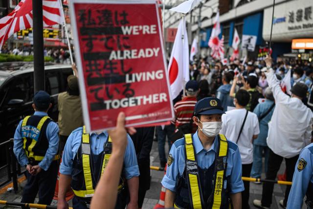 A counter protester holds up a sign during a nationalist rally near Ikebukuro Station in Tokyo's Toshima district on May 4, 2026, where participants called for stricter immigration controls and denounced the Japan Communist Party. (Photo by Andrew CABALLERO-REYNOLDS / AFP)